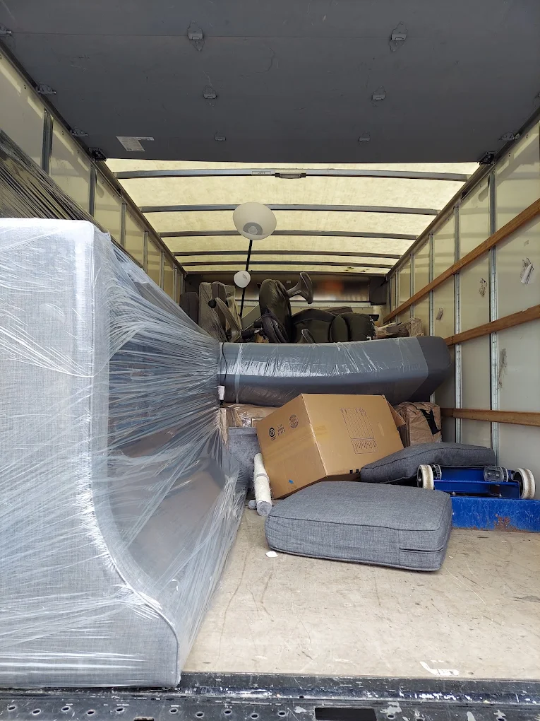 Shrink-wrapped sofa and boxes loaded in an Army Strong truck