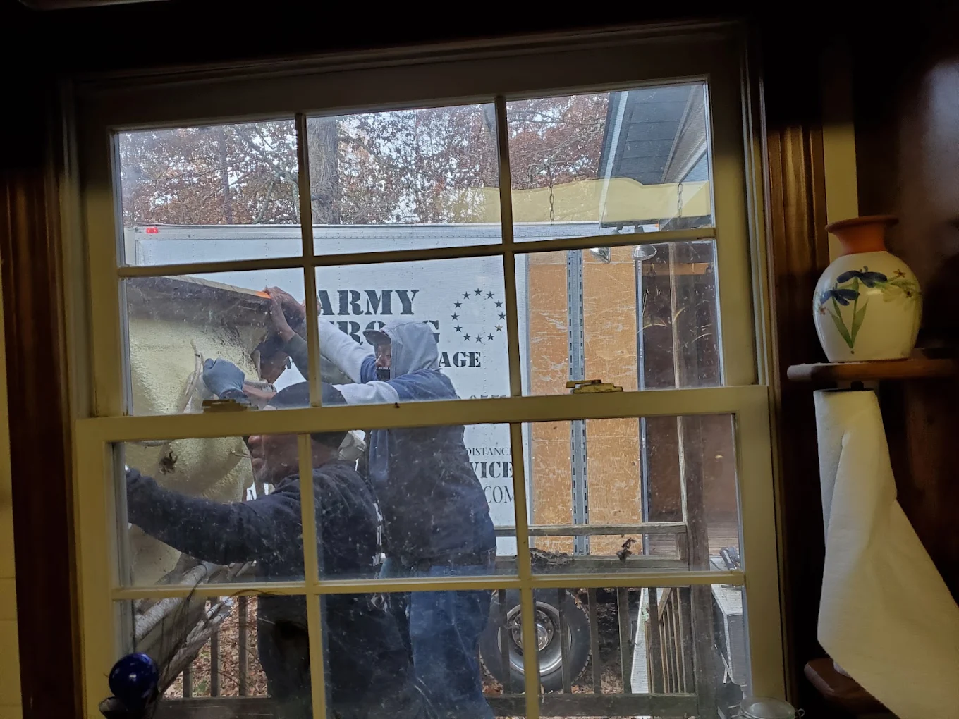 Two Army Strong movers working outside a customer's window